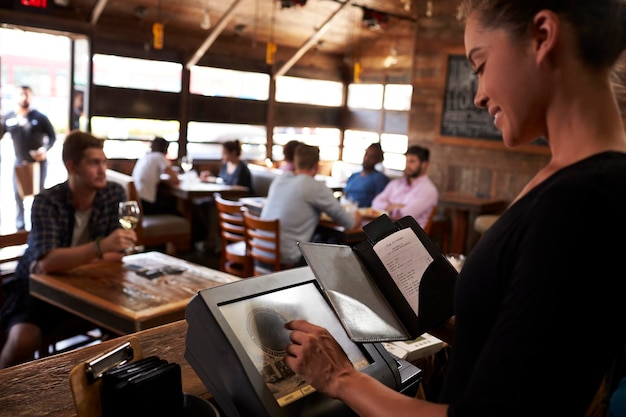 young-woman-preparing-bill-restaurant-using-touch-screen_625516-3032