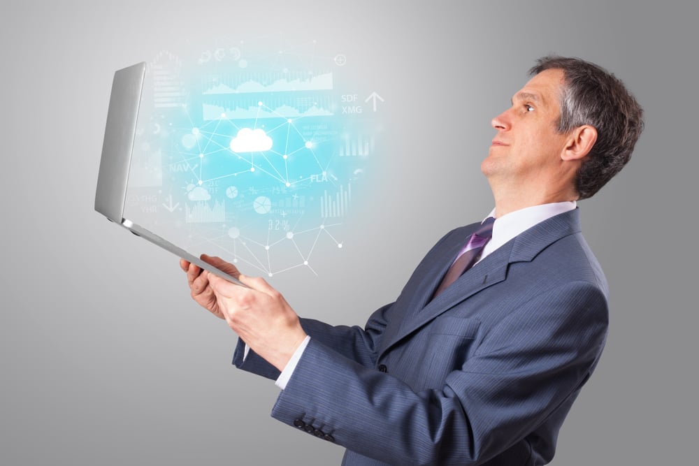 Man holding laptop projecting cloud based system symbols and informations